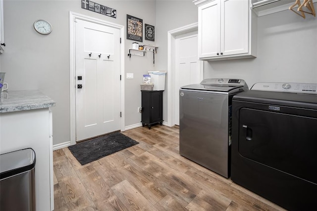 1225 N Nature Way, Mustang, OK 73064 - washroom featuring cabinet space, washer and dryer, light wood-type flooring, and baseboards