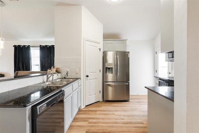 2304 NW 196th Ter, Edmond, OK 73012 - kitchen with stainless steel refrigerator with ice dispenser, dishwasher, a sink, light wood-style flooring, and a peninsula