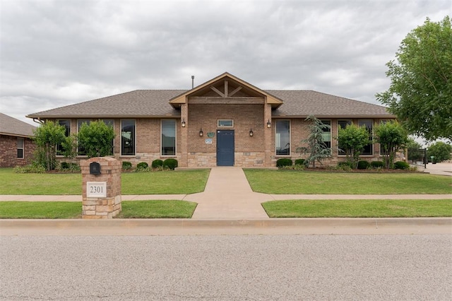 2304 NW 196th Ter, Edmond, OK 73012 - view of front of house featuring a front yard, brick siding, and roof with shingles