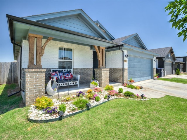 13325 SW 5th St, Yukon, OK 73099 - view of front of property with brick siding, an attached garage, concrete driveway, and a porch