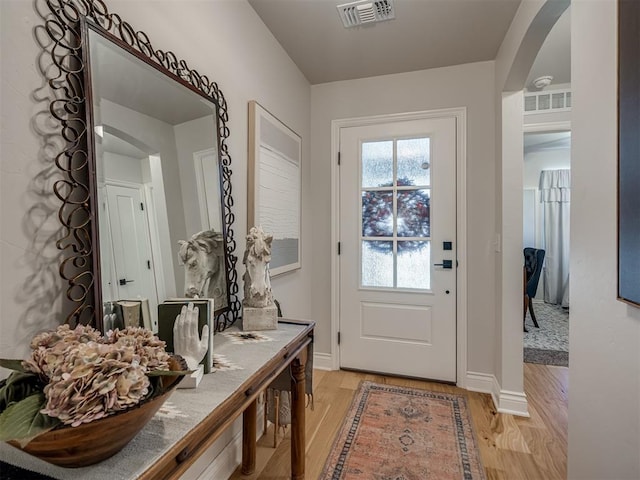 13325 SW 5th St, Yukon, OK 73099 - doorway to outside featuring arched walkways, light wood-style floors, and baseboards