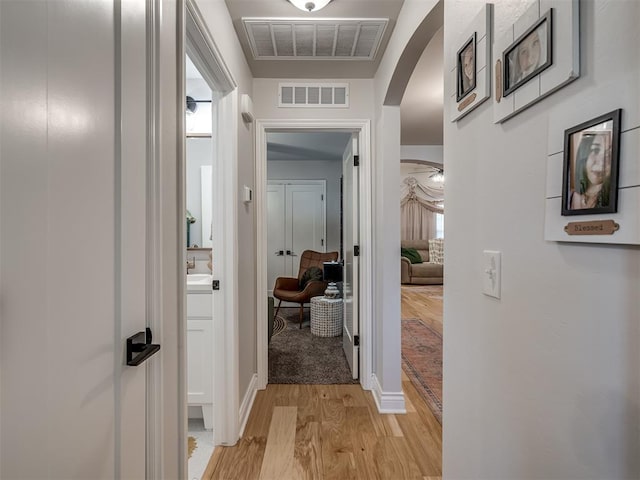 13325 SW 5th St, Yukon, OK 73099 - hall with arched walkways, light wood-style floors, and baseboards