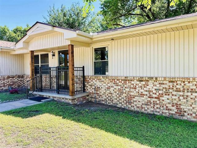 1312 N Carol Ln, Oklahoma City, OK 73127 - view of exterior entry with brick siding, a lawn, and covered porch