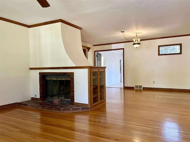 1312 N Carol Ln, Oklahoma City, OK 73127 - unfurnished living room featuring wood finished floors, ornamental molding, baseboards, a fireplace, and ceiling fan