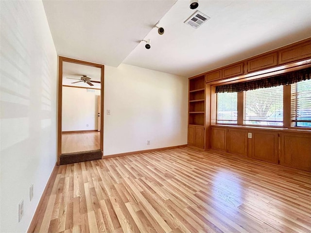 1312 N Carol Ln, Oklahoma City, OK 73127 - unfurnished room featuring light wood-style floors, rail lighting, built in features, and baseboards