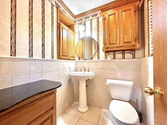 1312 N Carol Ln, Oklahoma City, OK 73127 - bathroom with tile patterned flooring, toilet, a wainscoted wall, and tile walls