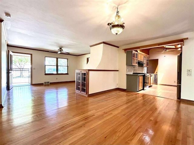 1312 N Carol Ln, Oklahoma City, OK 73127 - unfurnished living room with ceiling fan, light wood-style flooring, crown molding, and baseboards