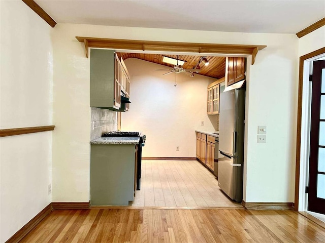 1312 N Carol Ln, Oklahoma City, OK 73127 - kitchen with stainless steel appliances, a ceiling fan, light wood-style flooring, light countertops, and baseboards
