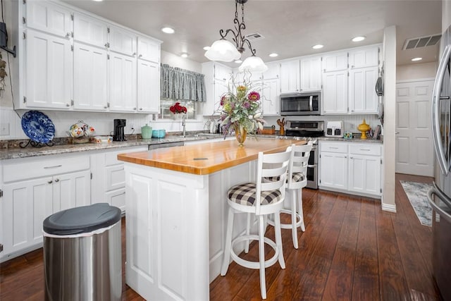 1889 Cobblestone Rd, Sulphur, OK 73086 - kitchen with appliances with stainless steel finishes, wooden counters, white cabinetry, a kitchen island, and dark wood-style floors