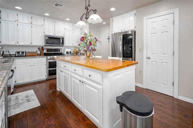1889 Cobblestone Rd, Sulphur, OK 73086 - kitchen featuring appliances with stainless steel finishes, dark wood-style flooring, white cabinetry, a kitchen island, and recessed lighting