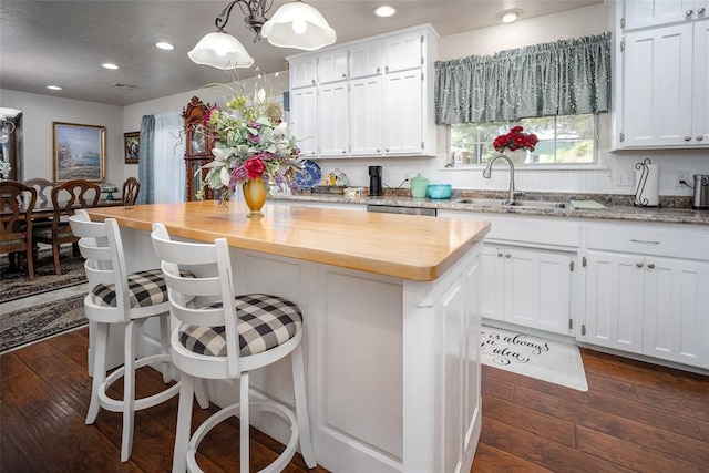 1889 Cobblestone Rd, Sulphur, OK 73086 - kitchen featuring butcher block counters, white cabinetry, a center island, dark wood finished floors, and recessed lighting