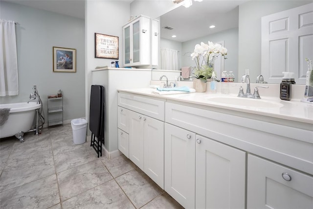 1889 Cobblestone Rd, Sulphur, OK 73086 - bathroom with double vanity, a freestanding bath, recessed lighting, and marble look tiles