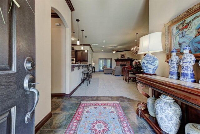 13009 Jasmine Ln, Oklahoma City, OK 73142 - entrance foyer featuring arched walkways, baseboards, stone tile flooring, crown molding, and a ceiling fan