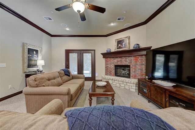13009 Jasmine Ln, Oklahoma City, OK 73142 - carpeted living room with crown molding, baseboards, a ceiling fan, french doors, and a fireplace