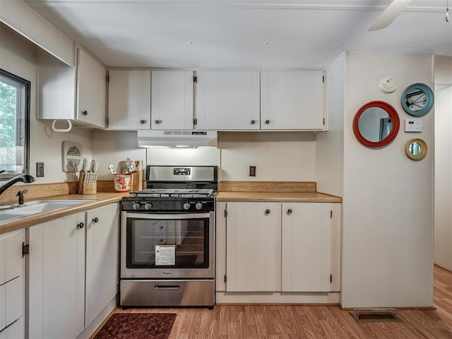 332 Royal Ln, Canadian, OK 74425 - kitchen featuring stainless steel range with gas cooktop, under cabinet range hood, light wood-style floors, light countertops, and white cabinetry