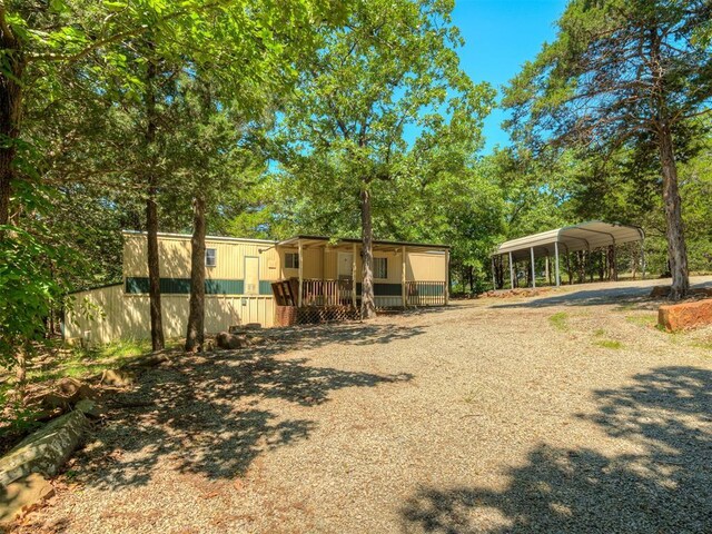 332 Royal Ln, Canadian, OK 74425 - back of house featuring a carport, driveway, and covered porch