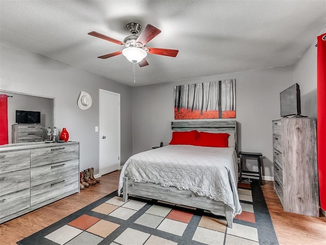 12601 Rock Springs Rd, Jones, OK 73049 - bedroom featuring ceiling fan, a textured ceiling, wood finished floors, and baseboards