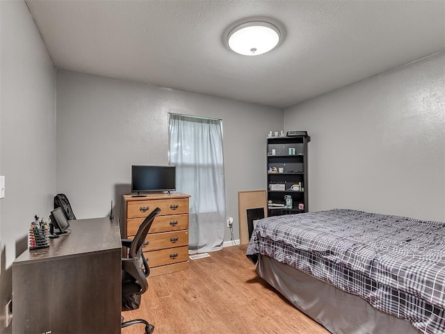 12601 Rock Springs Rd, Jones, OK 73049 - bedroom with light wood finished floors, a desk, and a textured wall
