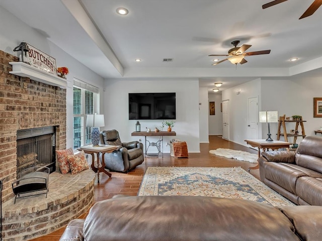 20486 Cypress Way, Tecumseh, OK 74873 - living area with a ceiling fan, wood finished floors, a fireplace, baseboards, and a tray ceiling