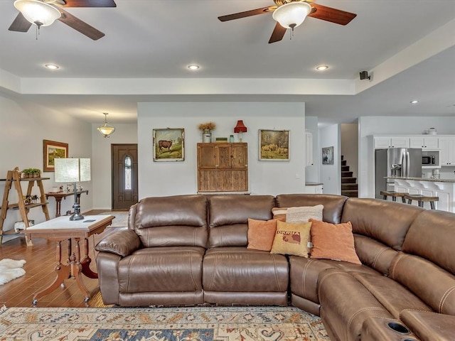 20486 Cypress Way, Tecumseh, OK 74873 - living room featuring a ceiling fan, wood-type flooring, recessed lighting, stairway, and a raised ceiling
