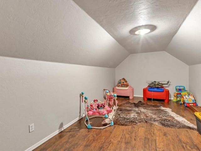 20486 Cypress Way, Tecumseh, OK 74873 - recreation room featuring a textured ceiling, wood finished floors, vaulted ceiling, and baseboards