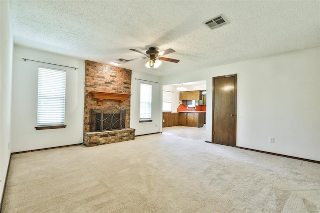 1101 S English St, Moore, OK 73160 - unfurnished living room featuring a ceiling fan, a fireplace, carpet, a textured ceiling, and baseboards