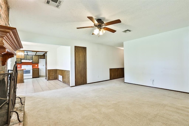 1101 S English St, Moore, OK 73160 - unfurnished living room featuring ceiling fan, a textured ceiling, light carpet, and wainscoting