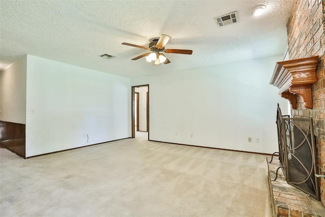 1101 S English St, Moore, OK 73160 - unfurnished living room with ceiling fan, a textured ceiling, carpet flooring, baseboards, and a fireplace