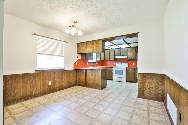 1101 S English St, Moore, OK 73160 - kitchen featuring white range with electric cooktop, wainscoting, under cabinet range hood, a peninsula, and wooden walls