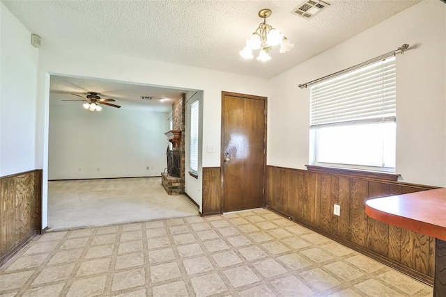 1101 S English St, Moore, OK 73160 - unfurnished dining area featuring a chandelier, wainscoting, wood walls, light flooring, and a textured ceiling