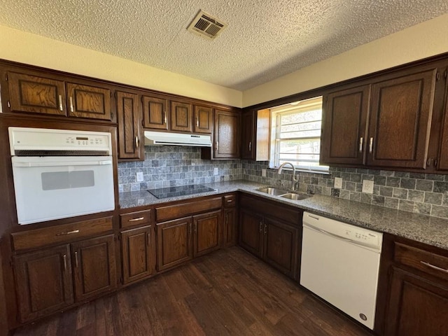 19 Mohican Cir, Shawnee, OK 74801 - kitchen featuring white appliances, a sink, under cabinet range hood, a textured ceiling, and dark wood finished floors