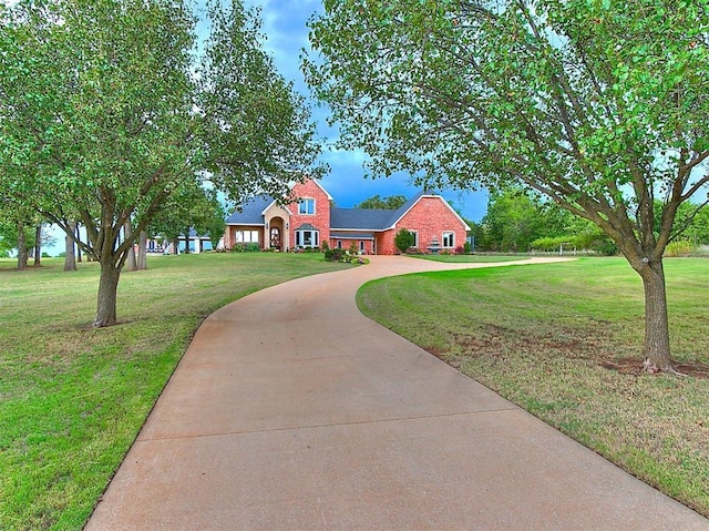 512 E Prairie Grove Rd, Guthrie, OK 73044 - traditional-style home featuring curved driveway, a front lawn, and brick siding