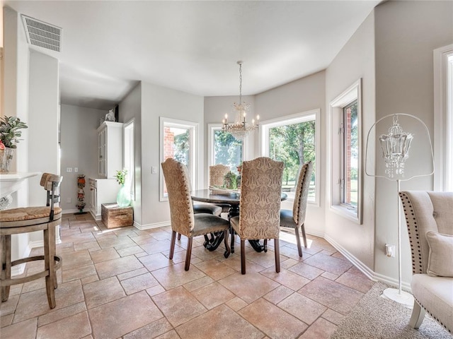 512 E Prairie Grove Rd, Guthrie, OK 73044 - dining space featuring a chandelier, stone tile flooring, and baseboards