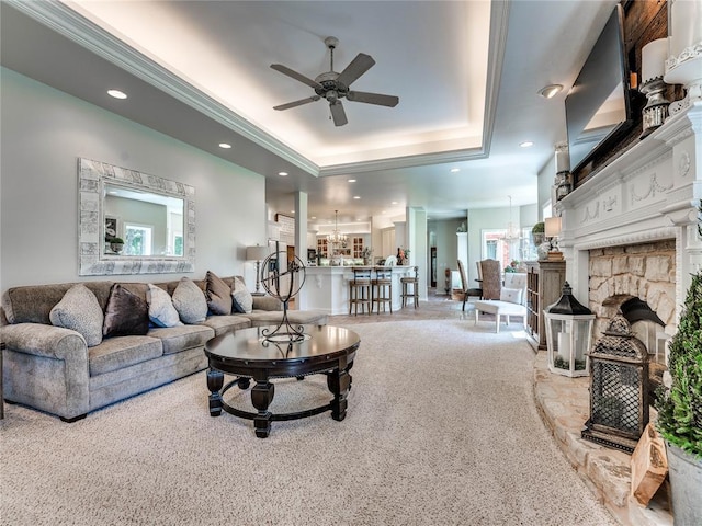 512 E Prairie Grove Rd, Guthrie, OK 73044 - carpeted living area with a tray ceiling, a ceiling fan, a chandelier, recessed lighting, and a stone fireplace