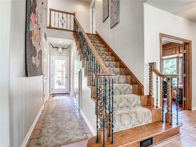 512 E Prairie Grove Rd, Guthrie, OK 73044 - stairs featuring plenty of natural light, baseboards, stone tile floors, and a towering ceiling