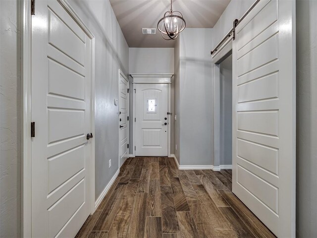 8109 NW 160th Ter, Edmond, OK 73013 - doorway featuring a barn door, dark wood-style floors, baseboards, and a chandelier