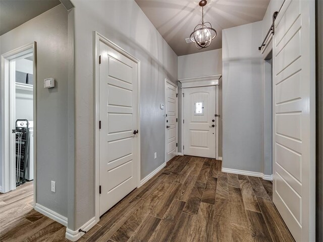 8109 NW 160th Ter, Edmond, OK 73013 - entryway with dark wood finished floors, a barn door, and baseboards