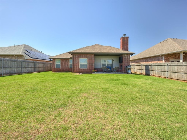 8109 NW 160th Ter, Edmond, OK 73013 - rear view of house featuring a chimney, brick siding, and a patio