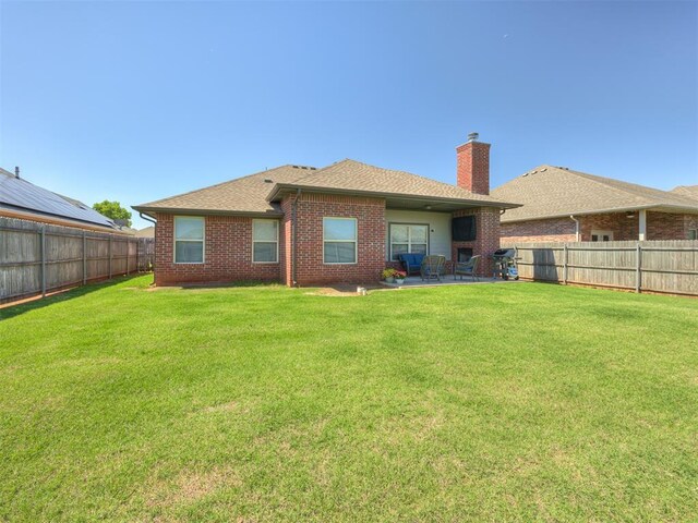 8109 NW 160th Ter, Edmond, OK 73013 - back of property featuring a patio, brick siding, a chimney, and a shingled roof