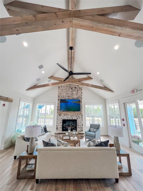 701 Montauk Way, Edmond, OK 73034 - living area with beam ceiling, a large fireplace, ceiling fan, wood finished floors, and baseboards