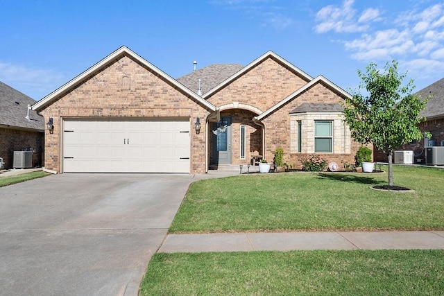 3409 Ontario Cir, Oklahoma City, OK 73160 - view of front of house with concrete driveway, an attached garage, a front lawn, cooling unit, and brick siding