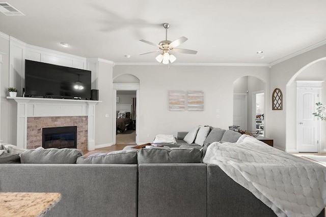 3409 Ontario Cir, Oklahoma City, OK 73160 - living area with arched walkways, ceiling fan, a tiled fireplace, ornamental molding, and baseboards