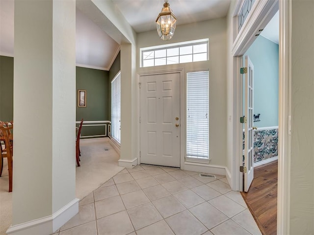 8413 NW 64th Ter, Oklahoma City, OK 73132 - foyer entrance with a chandelier, baseboards, light tile patterned floors, and crown molding