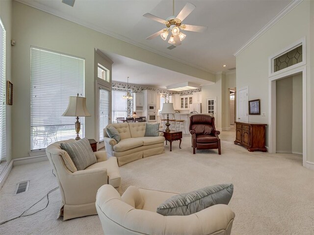 8413 NW 64th Ter, Oklahoma City, OK 73132 - living room featuring ornamental molding, light carpet, ceiling fan, baseboards, and a chandelier