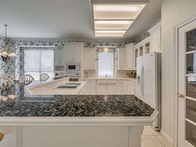 8413 NW 64th Ter, Oklahoma City, OK 73132 - kitchen with white appliances, a sink, light tile patterned floors, plenty of natural light, and wallpapered walls