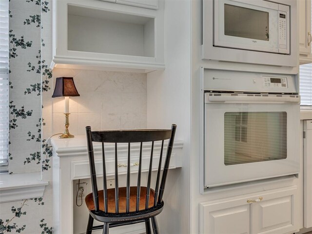 8413 NW 64th Ter, Oklahoma City, OK 73132 - detailed view of white appliances, tasteful backsplash, and white cabinetry
