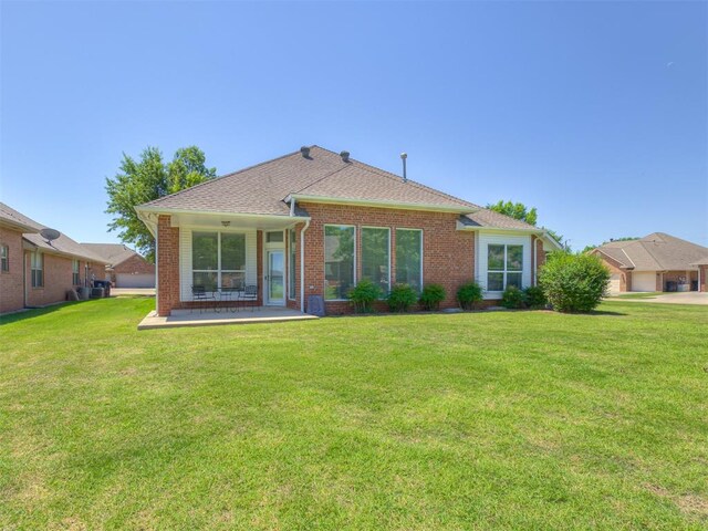 8413 NW 64th Ter, Oklahoma City, OK 73132 - rear view of house featuring brick siding, a yard, and a patio area