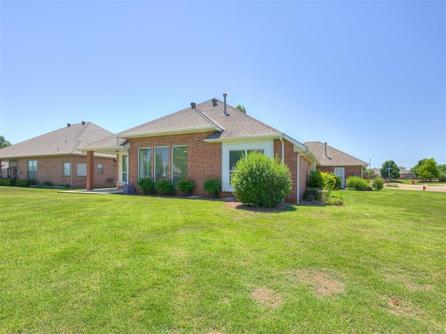 8413 NW 64th Ter, Oklahoma City, OK 73132 - back of house featuring brick siding and a lawn