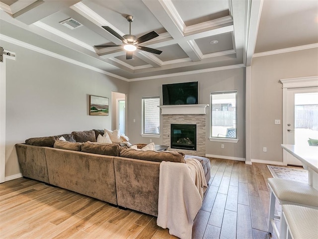 9212 NW 89th St, Yukon, OK 73099 - living area featuring ceiling fan, coffered ceiling, light wood-type flooring, a stone fireplace, and beam ceiling