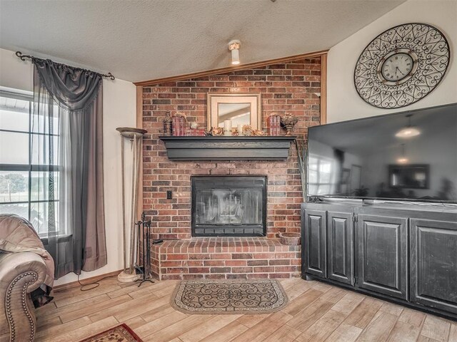 870756 S 3460th Rd, Chandler, OK 74834 - living area with a brick fireplace, lofted ceiling, light wood-style floors, and a textured ceiling